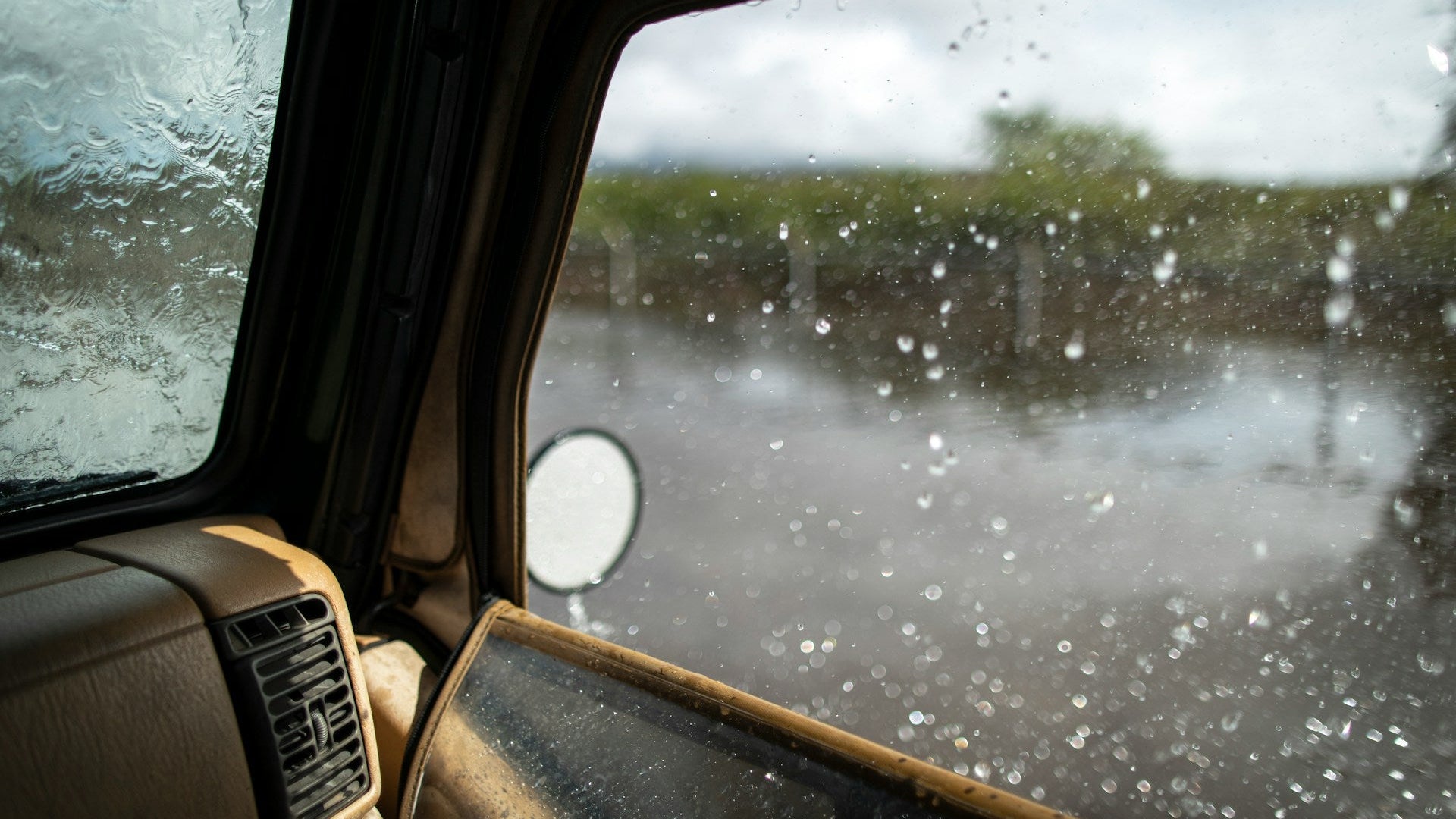 Inside view of a car with wet windshield on a rainy day