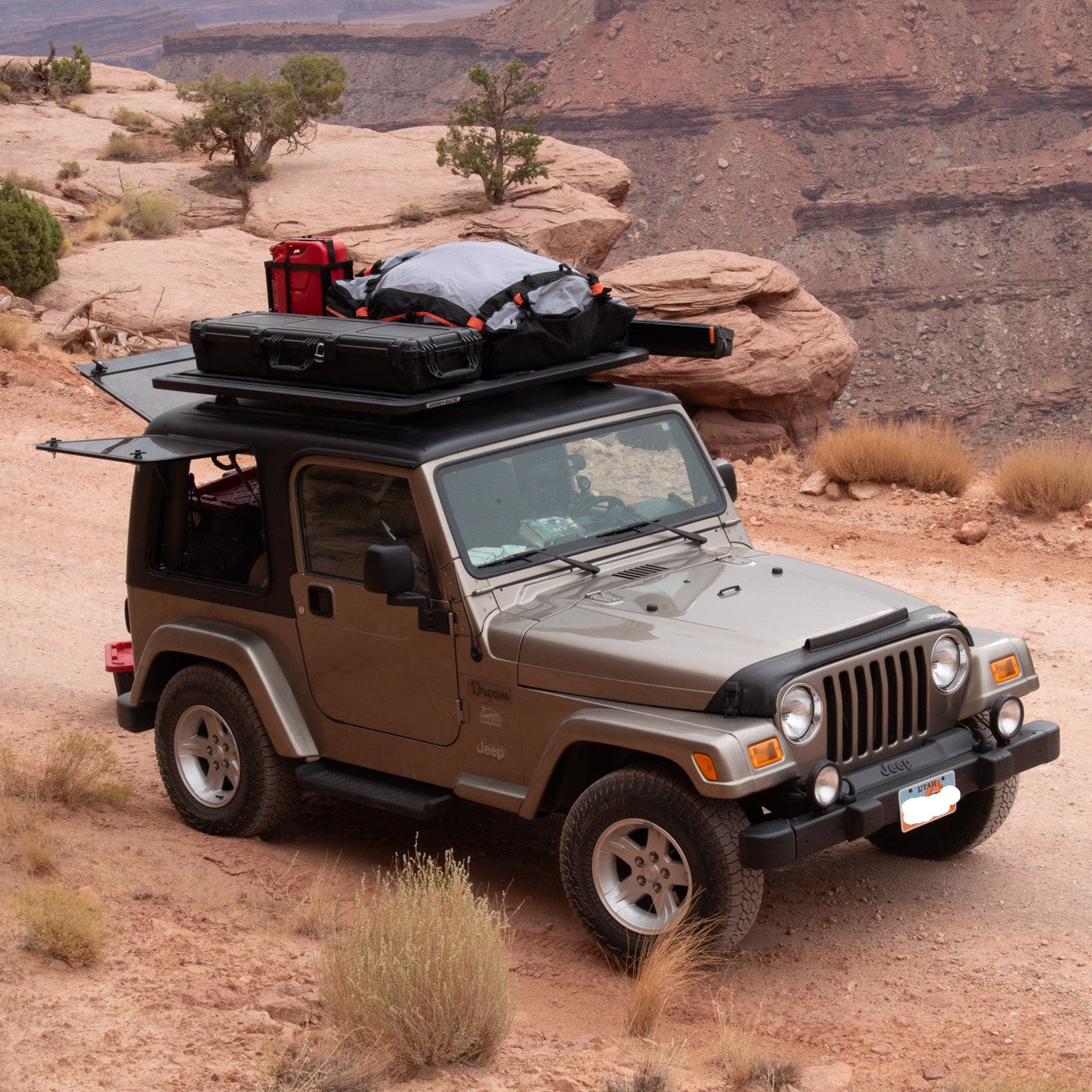 Jeep with roof racks and luggage in a desert landscape
