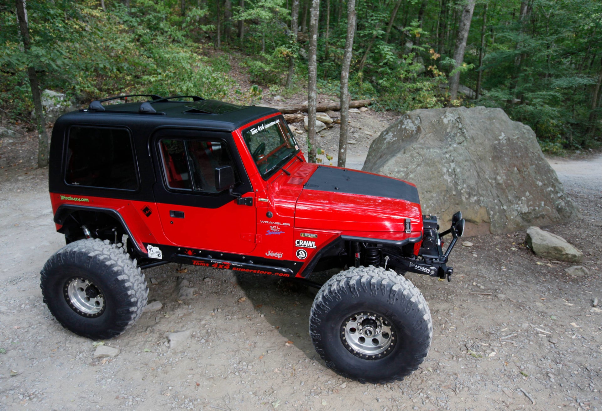 Red off-road vehicle on a dirt path with trees in the backgroundslider_item_D3ULkT