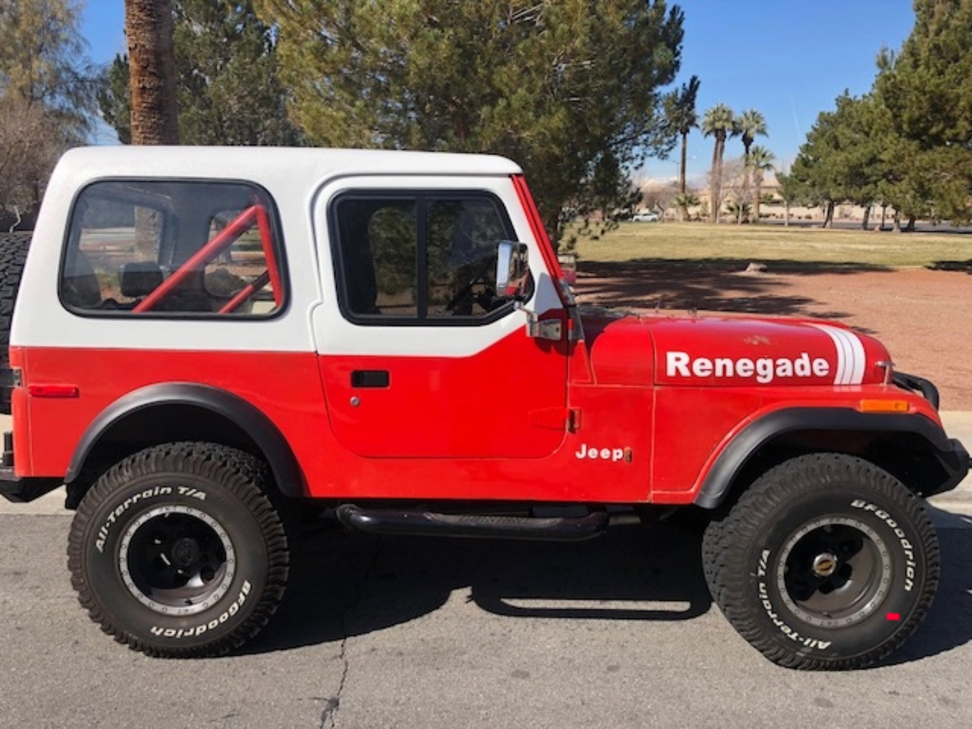 Red and white Jeep Renegade parked on a paved surface with trees in the backgroundslider_item_pGKzHL