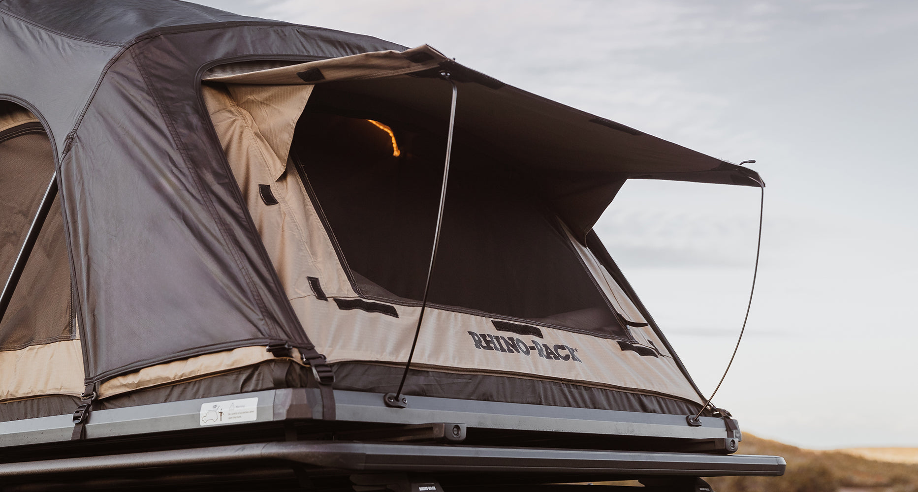 Roof top tent on a vehicle with 'BendPak' branding against a desert landscape.