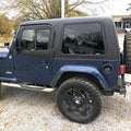 Blue Jeep Wrangler with black soft top parked outdoors