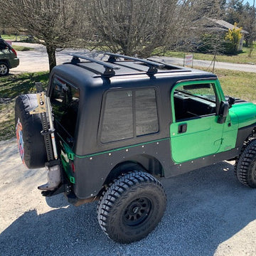 Green and black off-road vehicle parked on a driveway
