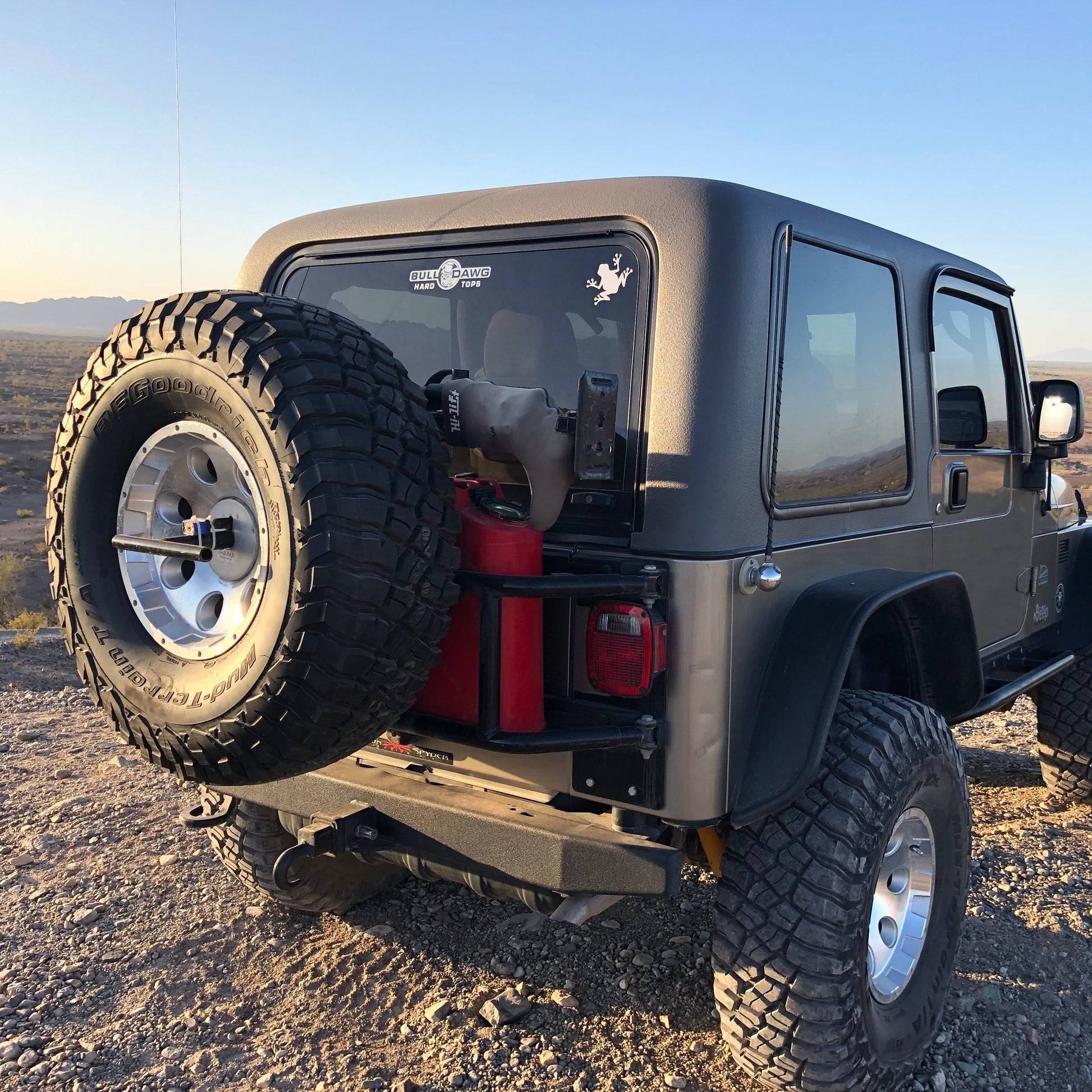 Jeep Wrangler in a desert setting with a spare tire on the back