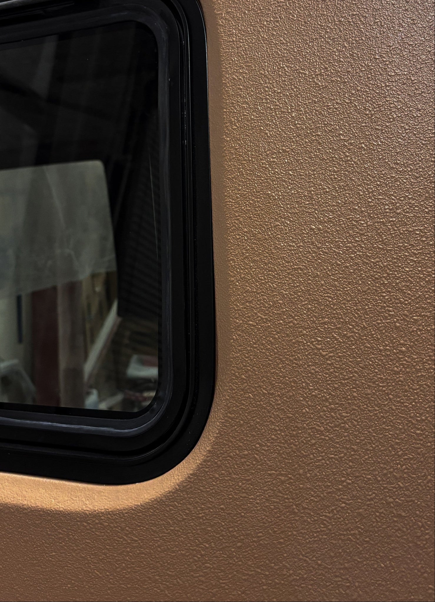 Small window with black frame on a beige wall