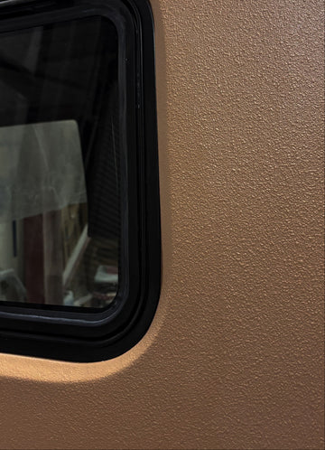 Small window with black frame on a beige wall