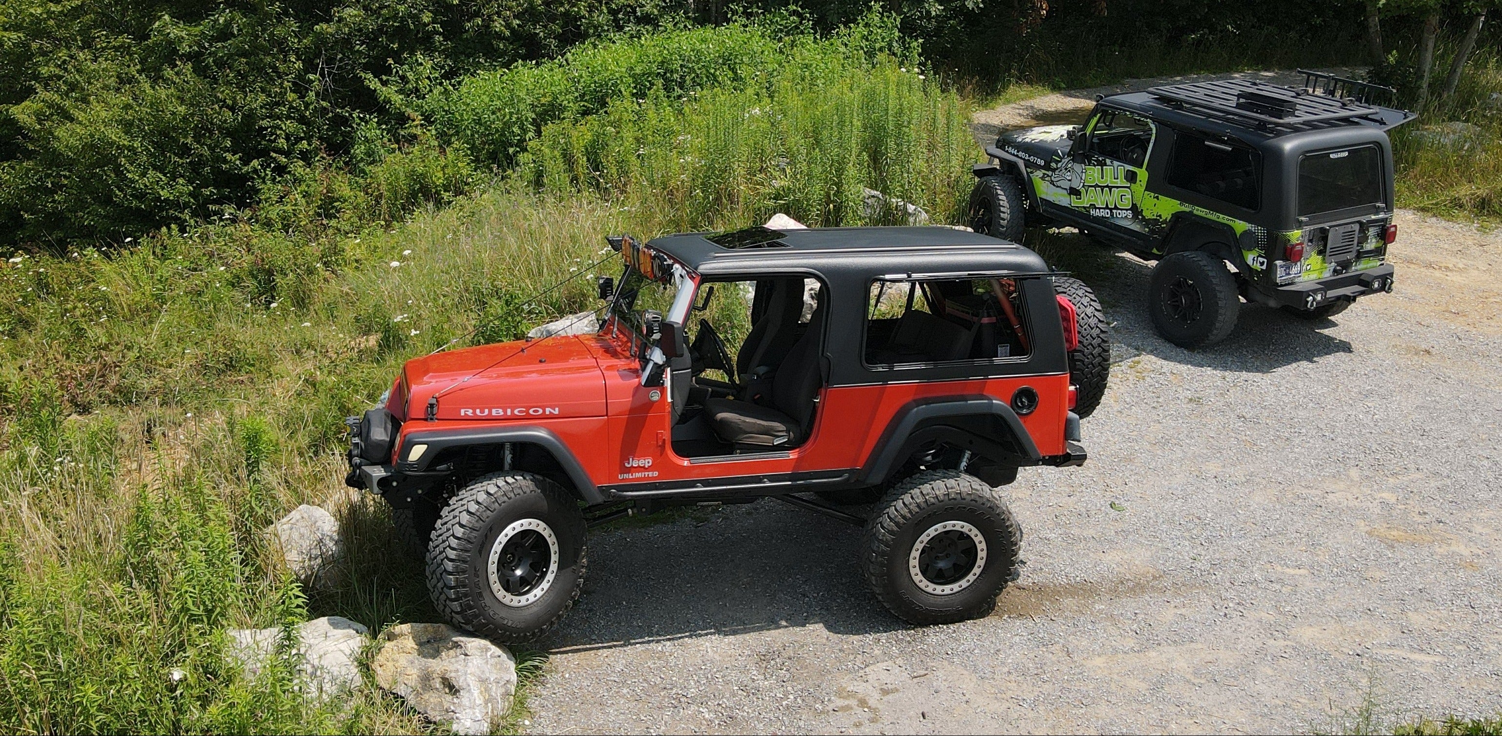 Two off-road vehicles on a gravel path with greenery in the background