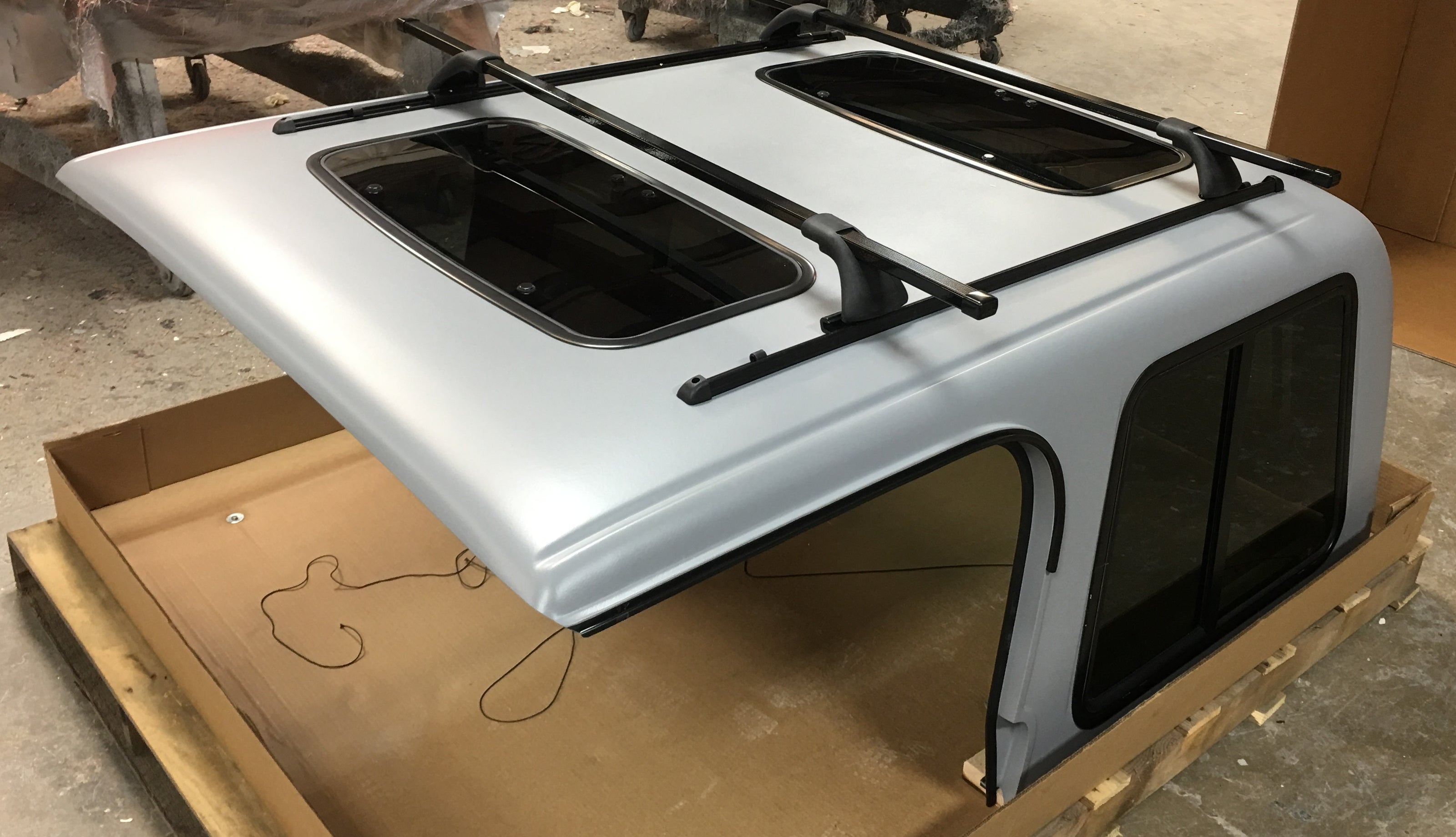 Car roof rack system on a white car with cardboard box underneath