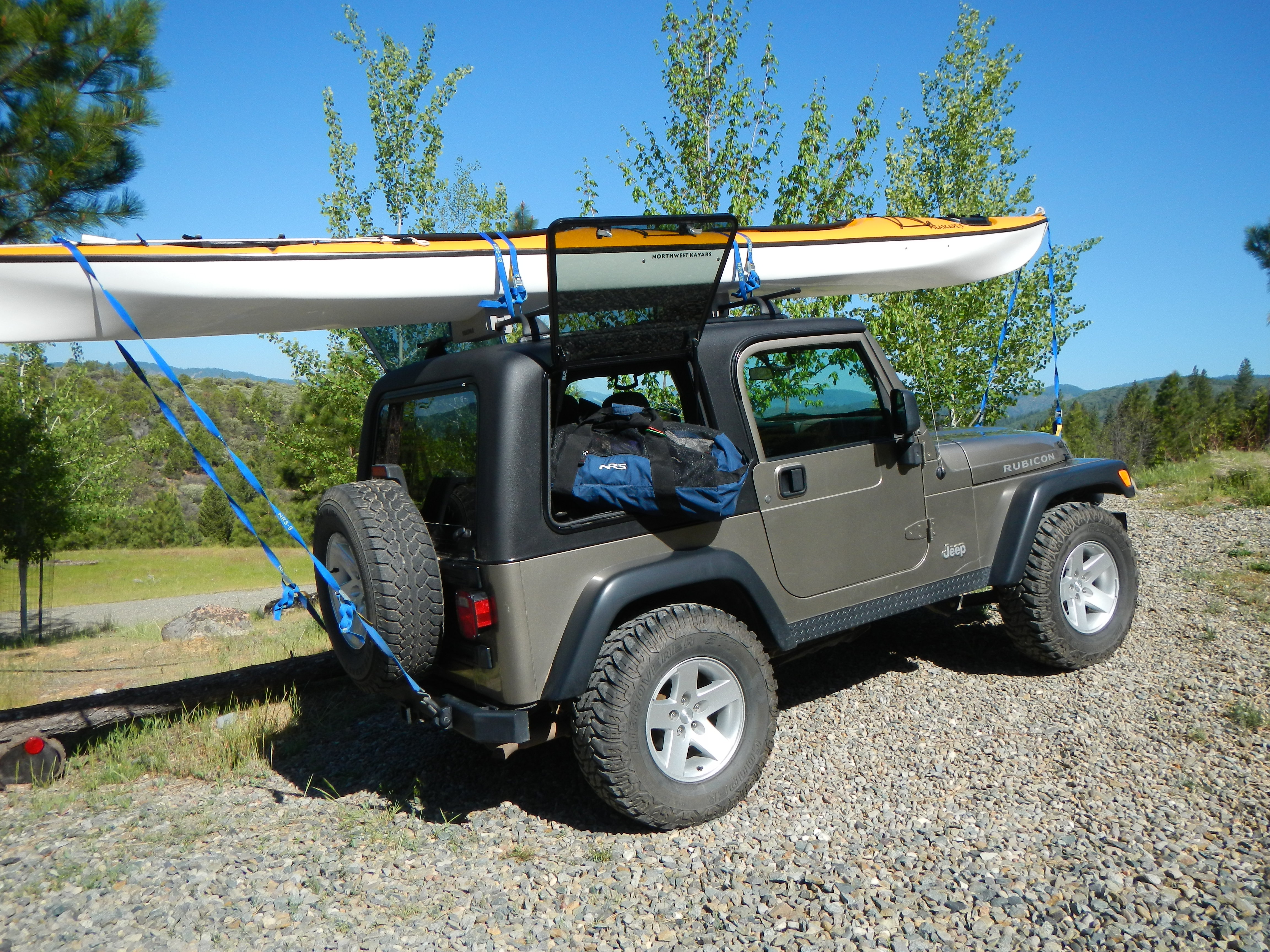 green hard-top-tj Jeep Wrangler carrying canoe